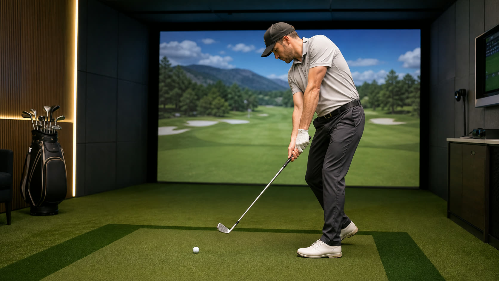 A golfer dropping the club into the slot during the downswing in an indoor simulator bay